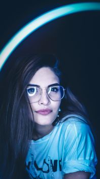 霓虹灯照亮眼镜的女人肖像，散发着现代的风格与态度