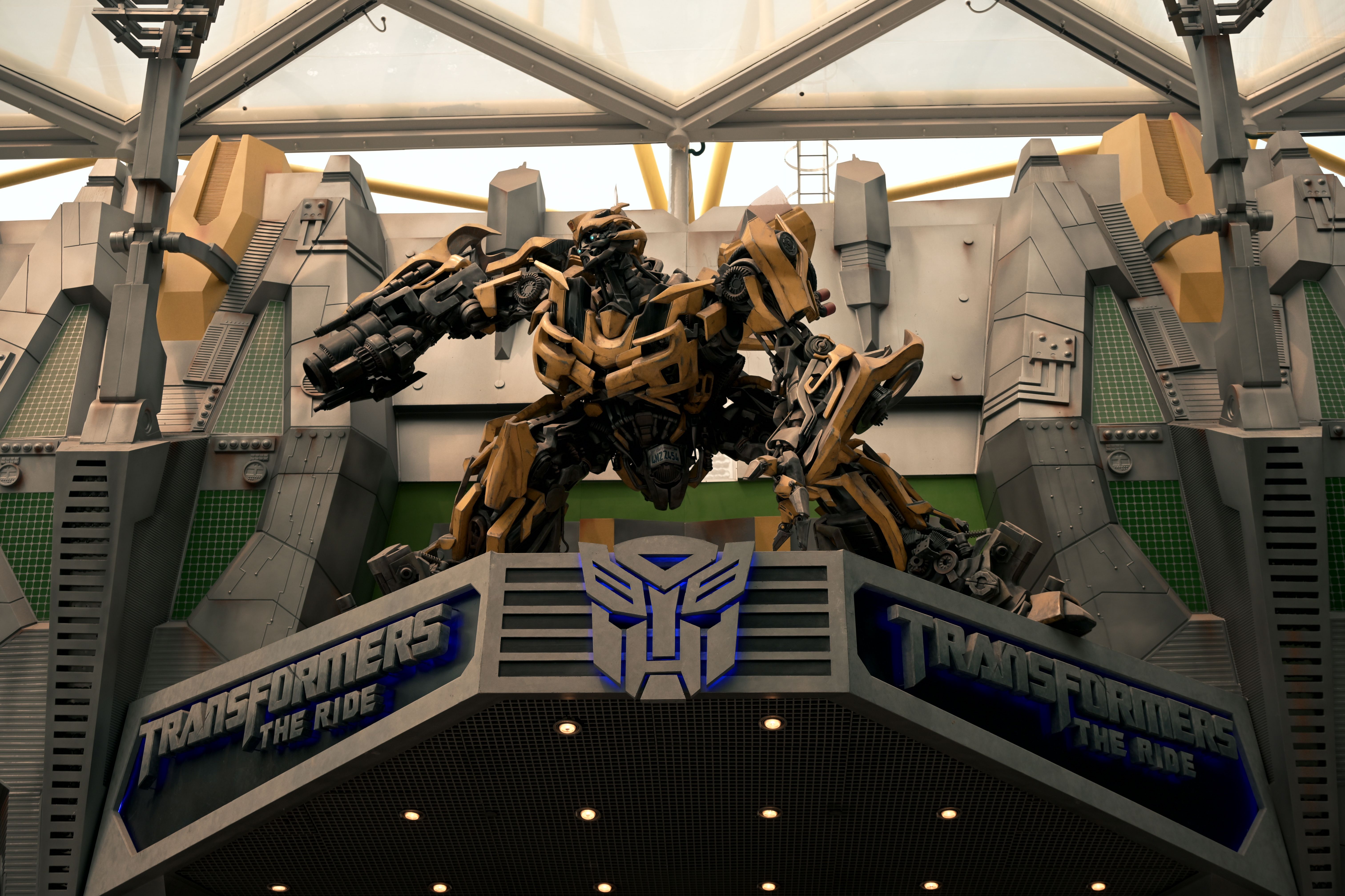 Transformers The Ride entrance featuring a large robot statue in a futuristic setting.