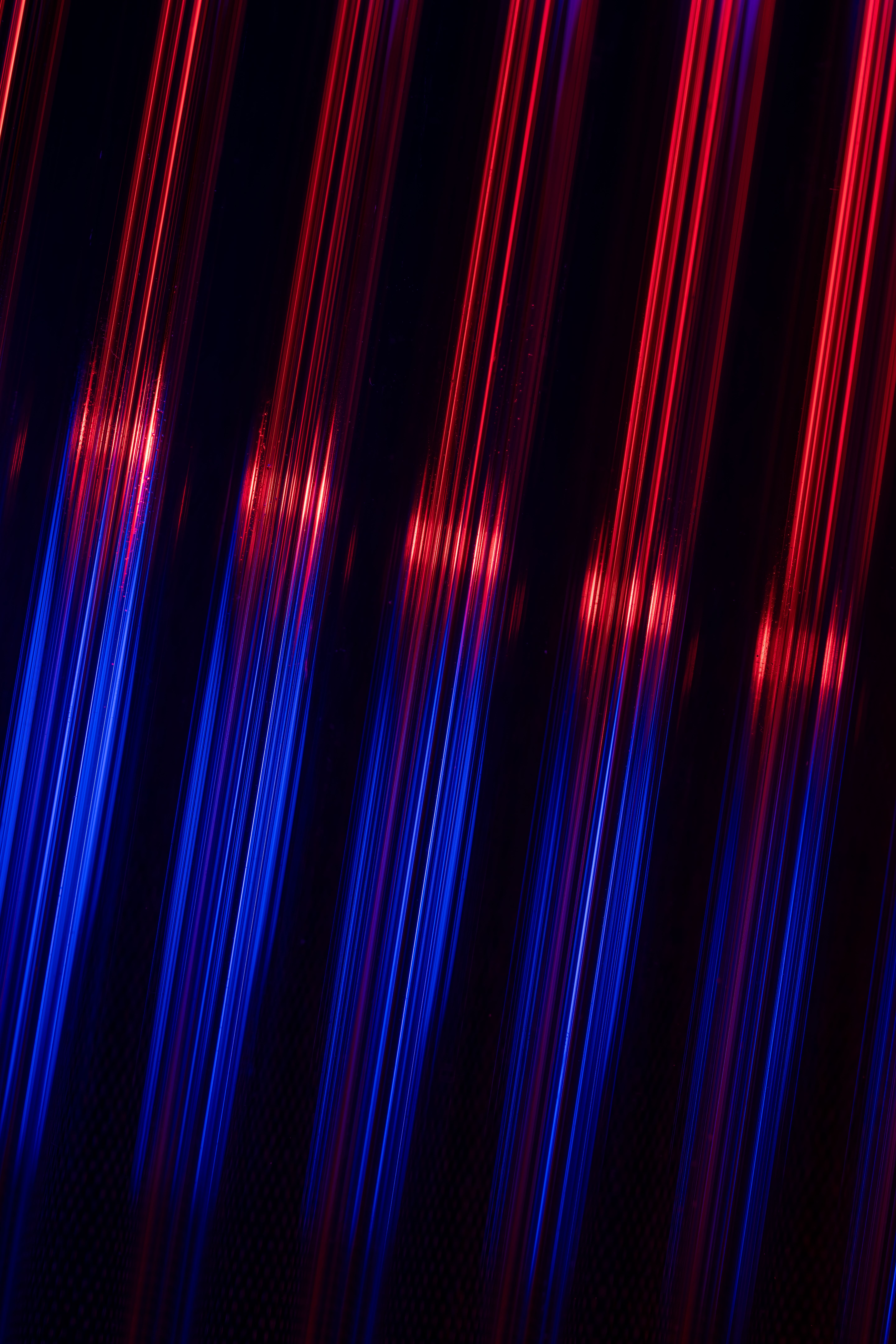 A vivid abstract display of neon red and blue light reflections with a futuristic feel.