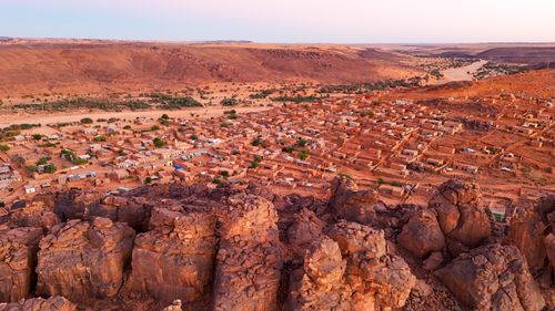 Free Drone view of a desert village surrounded by rock formations in Mauritania's Sahara. Stock Photo