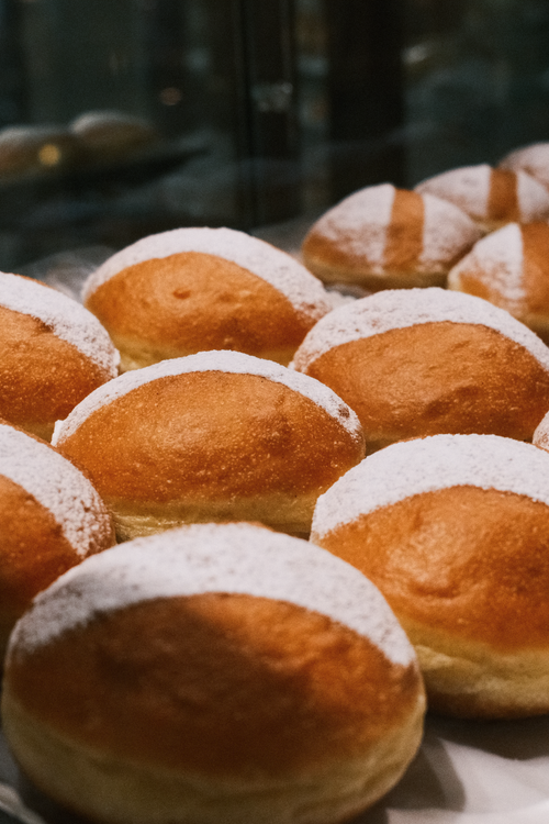 Free Freshly baked Austrian Krapfen dusted with powdered sugar, perfect for a sweet treat. Stock Photo