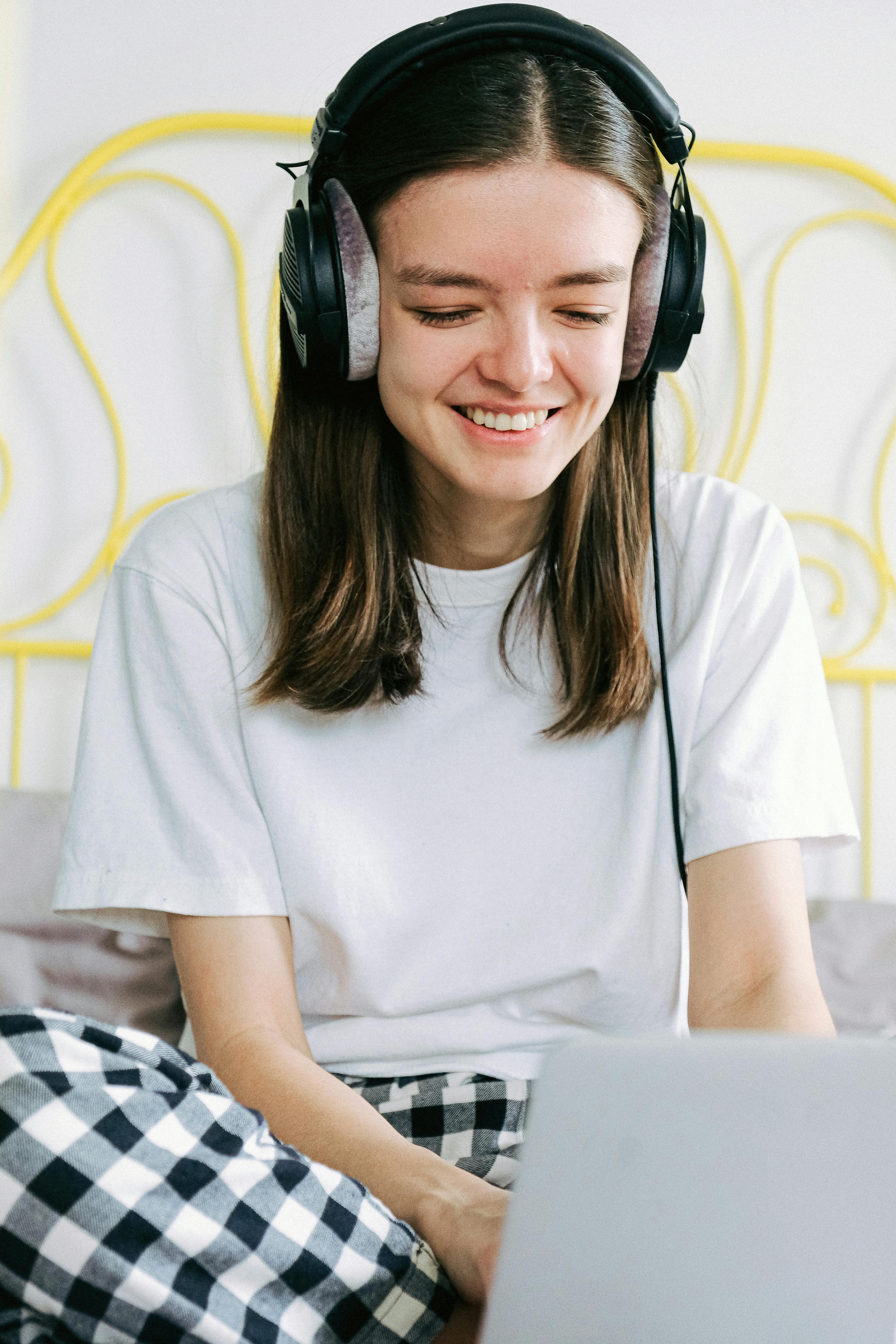 woman in white crew neck t shirt sitting on bed