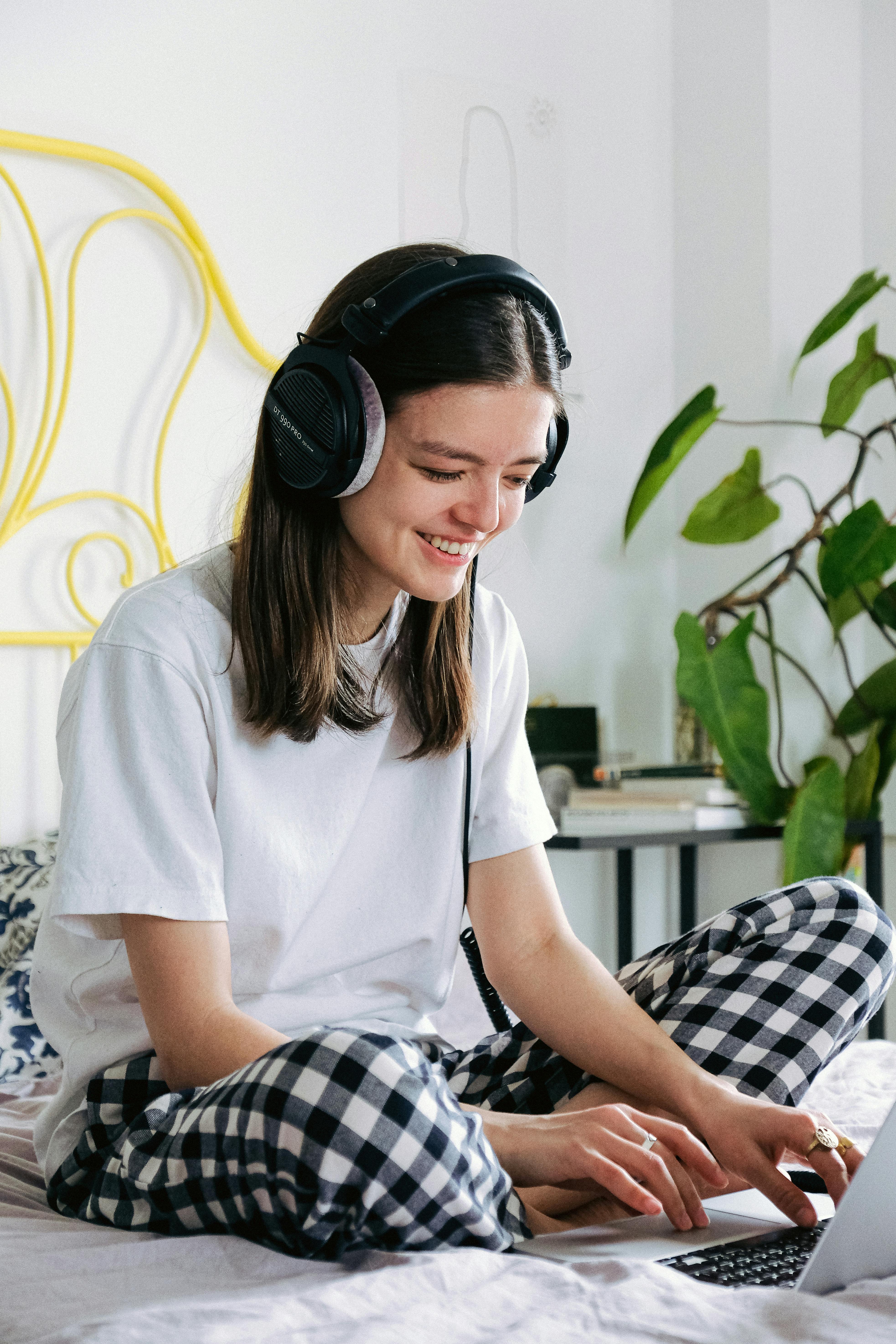 woman in white crew neck t shirt wearing black headphones