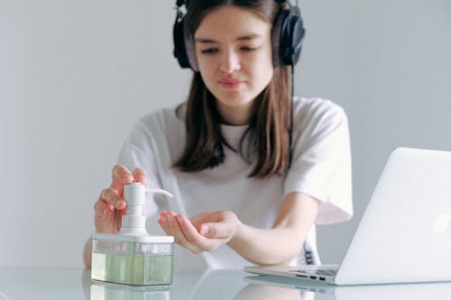 Woman In White Shirt Using Sanitizer