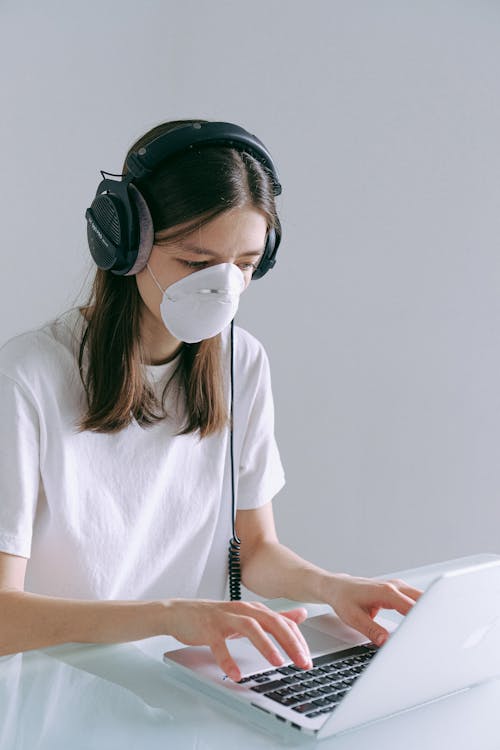 Woman In White Crew Neck T-shirt Wearing Headphones