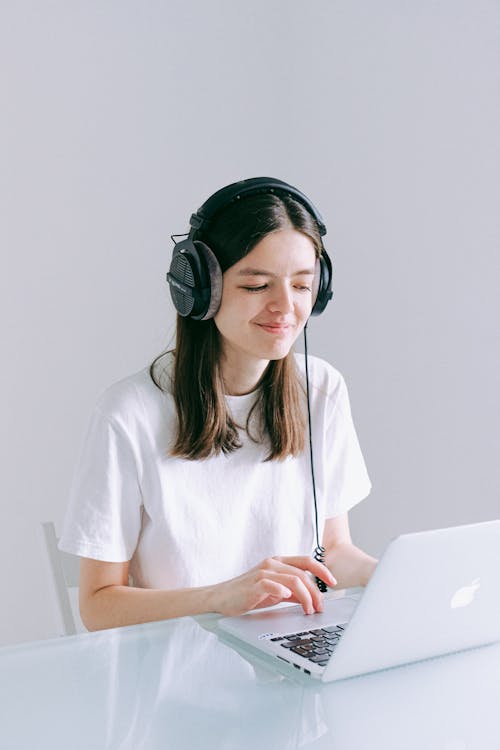 Free Woman In White Crew Neck T-shirt Using Laptop Computer Stock Photo