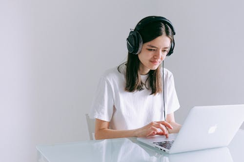 Free Woman In White T-shirt Using A Macbook  Stock Photo