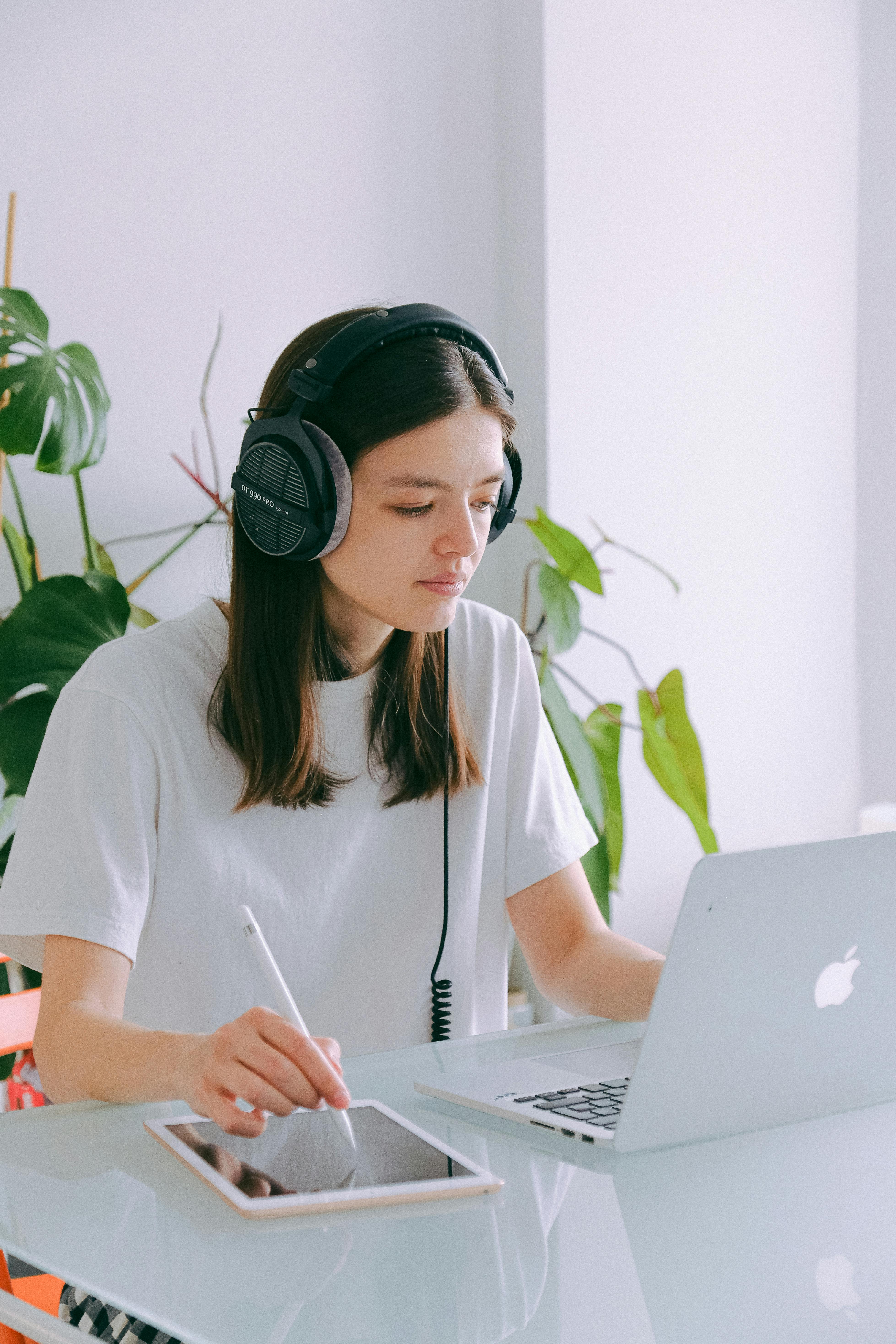 woman in white t shirt using macbook