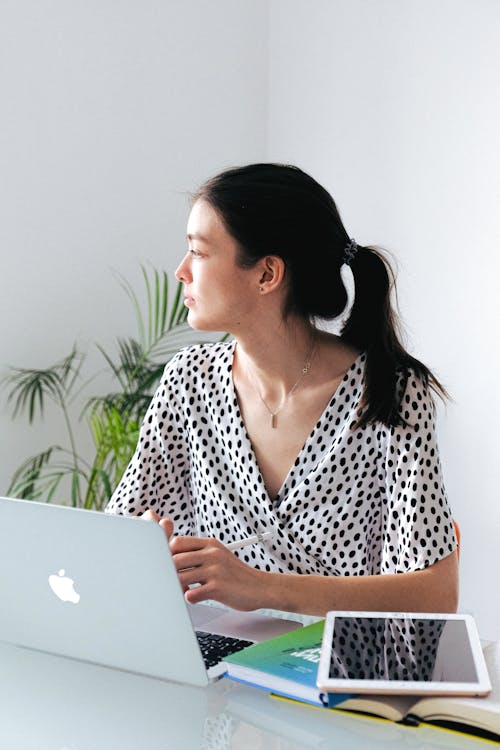 Woman In Black And White Polkadot Clothing Using Macbook