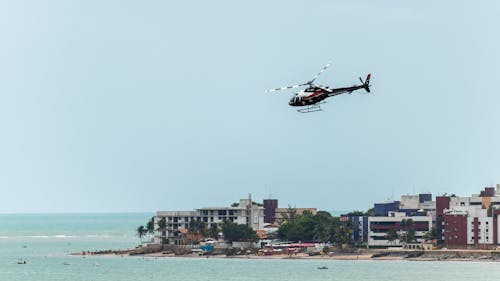 Helicopter Flying Over Body Of Water