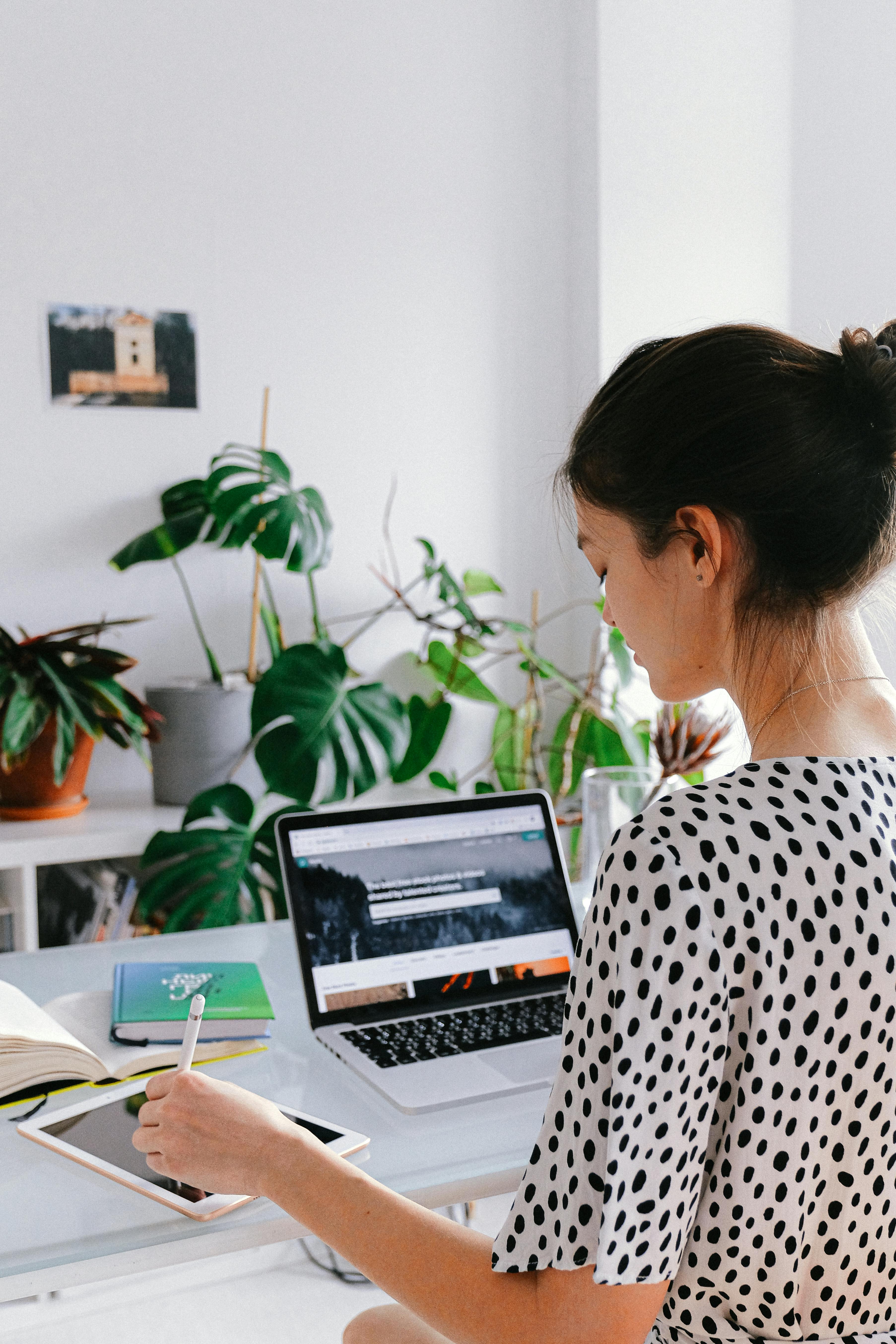 woman in black and white polka dot shirt using macbook pro