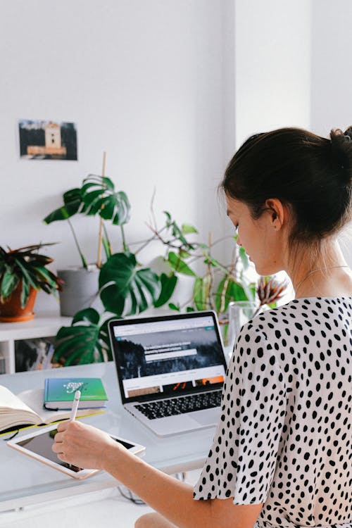 Woman In Black And White Polka Dot Shirt Using Macbook Pro