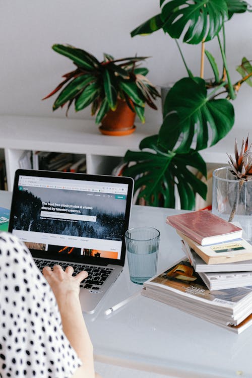 Free Person Using Macbook Pro on Table Stock Photo