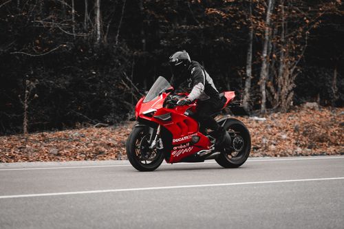 Free A thrilling ride on a red sports motorcycle along a scenic autumn road. Stock Photo