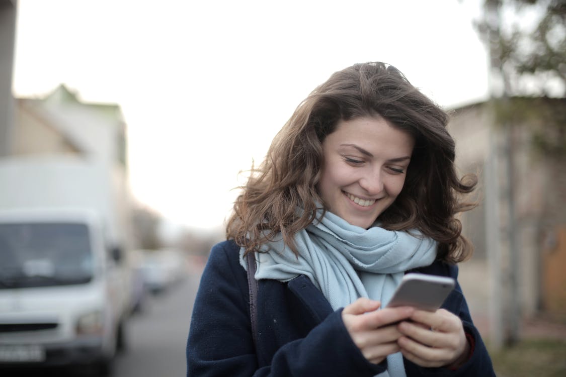 Woman in Blue Jacket Holding Smartphone · Free Stock Photo