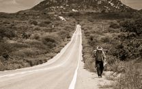 Grayscale Photo of Man Walking on Road