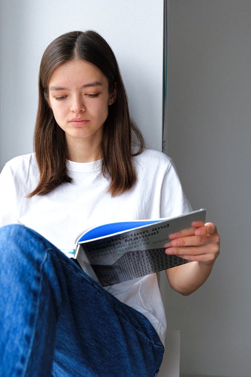 Woman In White Crew Neck T-shirt Holding A Book