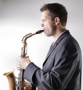 Side view of a saxophonist playing jazz music in a black suit.