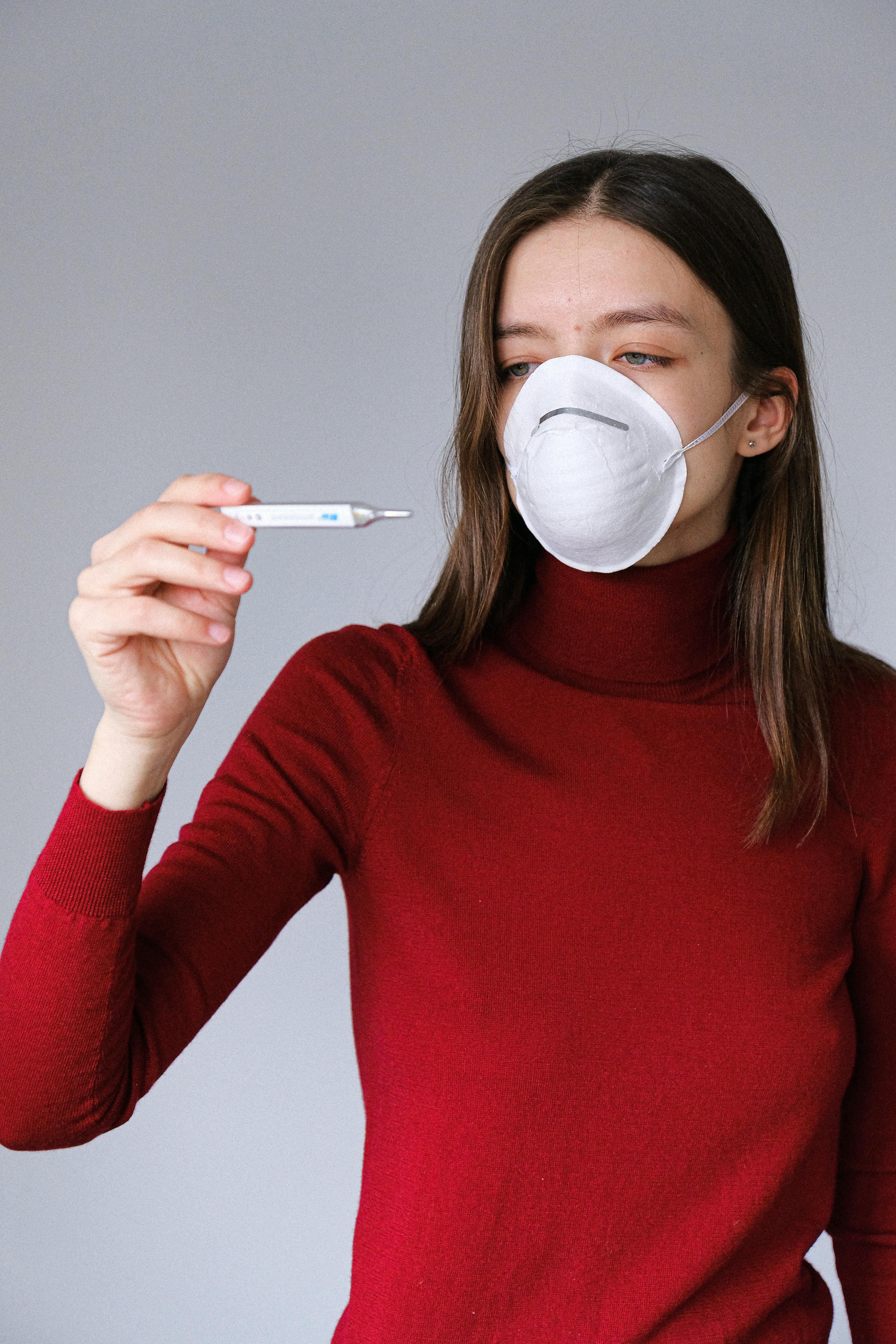 Free Woman in Face Mask Checking Thermometer Stock Photo