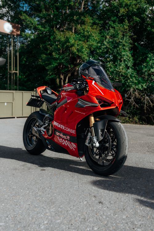 Free A striking red Ducati motorcycle parked outdoors on a sunny day, showcasing sleek design and vibrant colors. Stock Photo