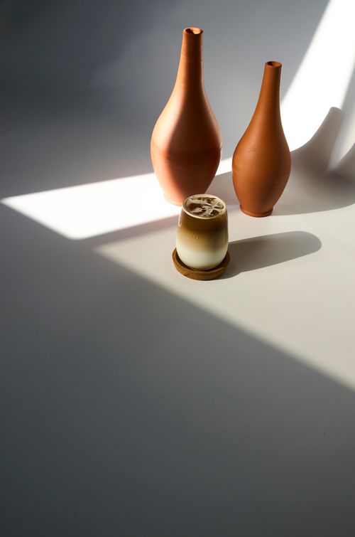 Free Aesthetic minimalist arrangement of ceramic vases and iced coffee in soft natural light. Stock Photo