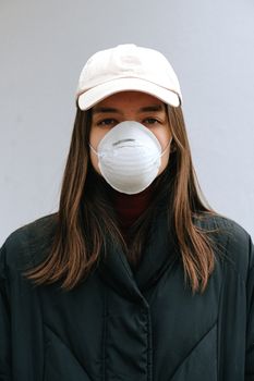 这是一幅年轻女子的肖像，她戴着口罩和棒球帽，强调了疫情期间健康与防护的重要性