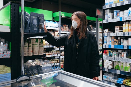 A woman wearing a face mask shops for groceries indoors, reflecting pandemic precautions.