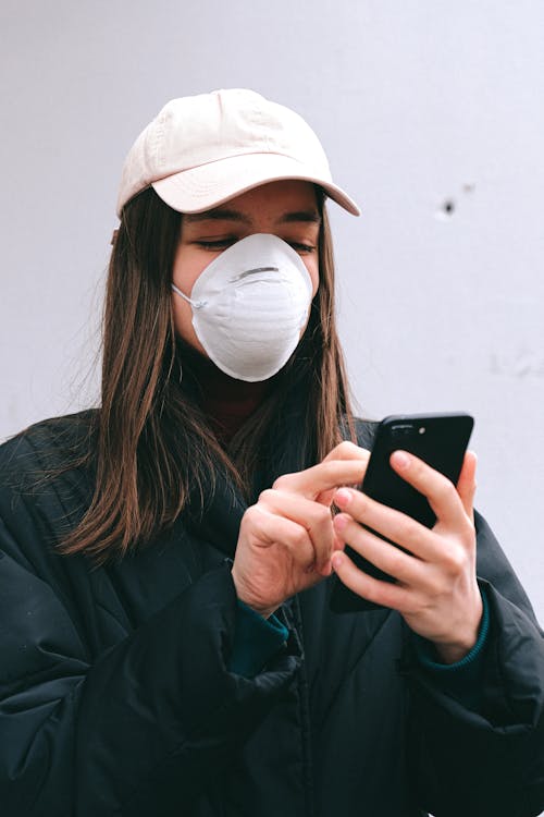 Free Woman in Face Mask Using Smartphone Stock Photo