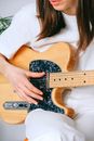 Woman in White Crew Neck T shirt Playing Brown and Black Electric Guitar