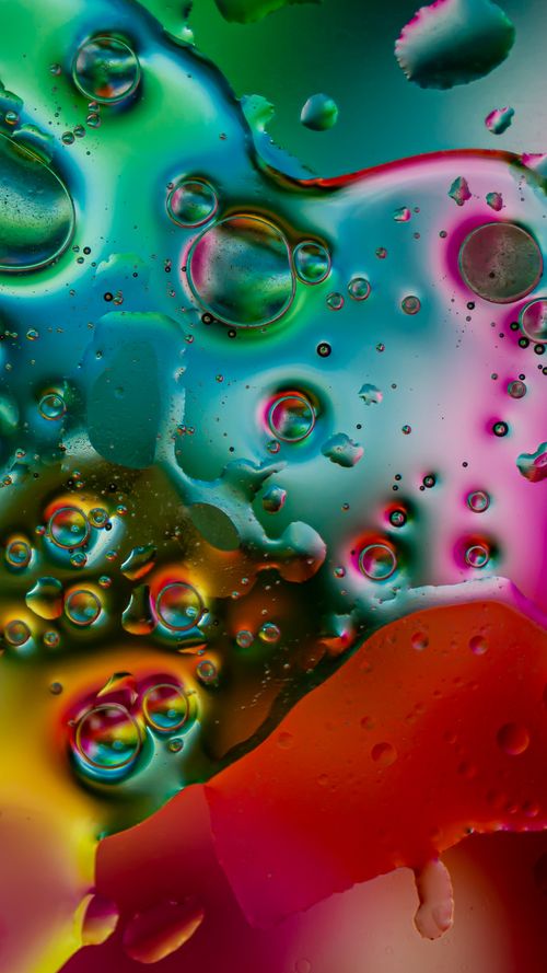 Free Colorful macro shot of oil bubbles in water creating abstract art with vivid hues. Stock Photo