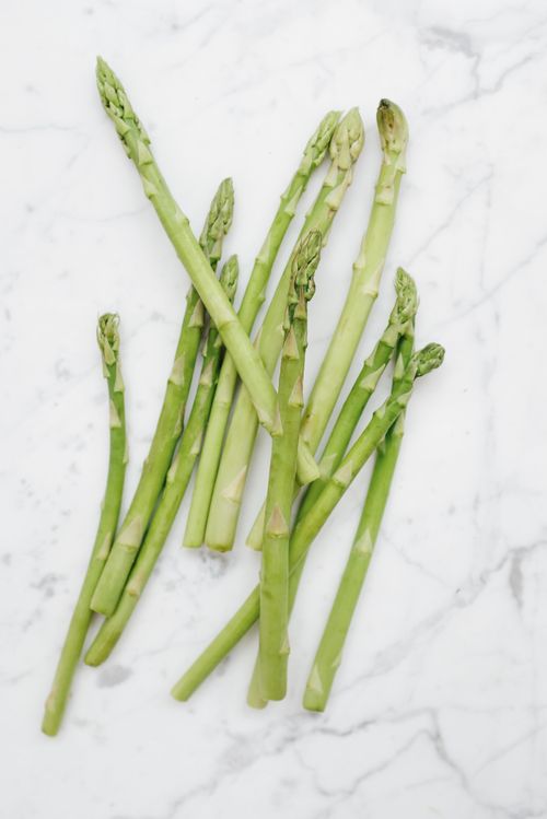 Free Close-up of fresh green asparagus on a marble background, ideal for healthy cooking and meal prep visuals. Stock Photo
