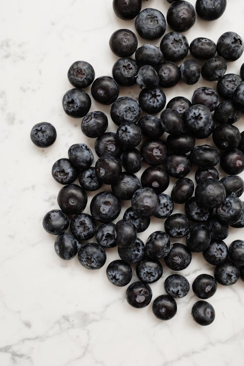 Black Round Fruits on White Ceramic Plate