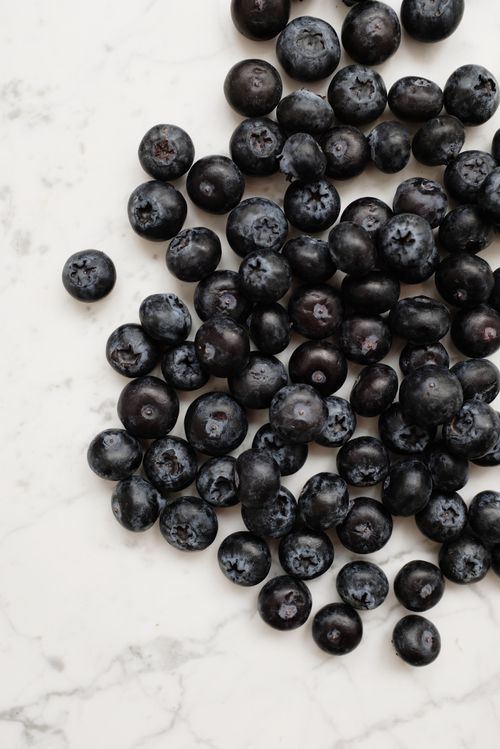 Free Close-up of fresh, juicy blueberries on a white marble background. Stock Photo