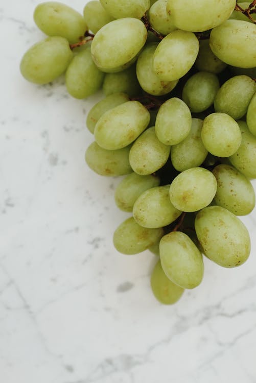 Close up of Green Sultana Grapes on White Surface 