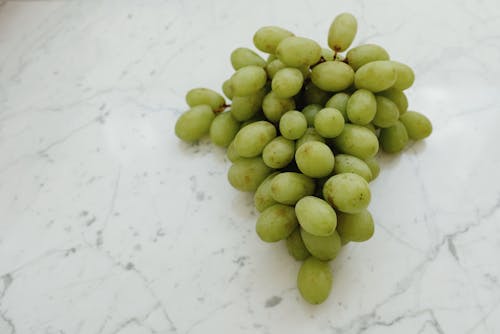Green Round Fruits on White Surface