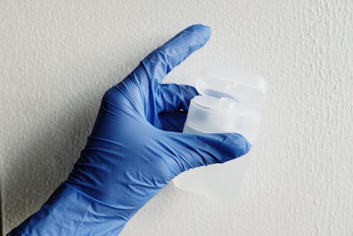 Free Person Wearing Blue Gloves Holding Plastic Container Stock Photo