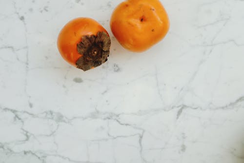 2 Orange Round Fruits on White Surface