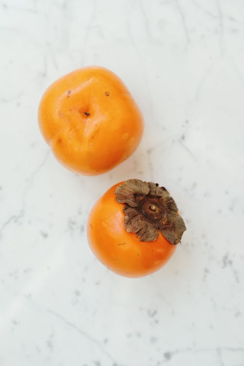 Persimmons on White Surface