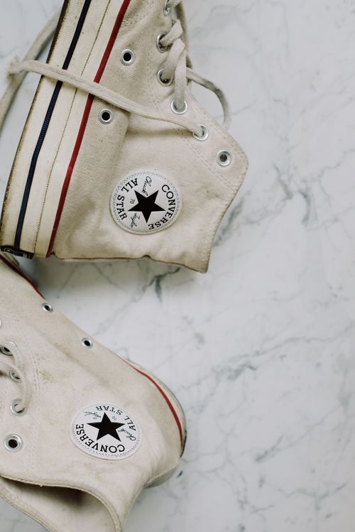 Free Close-up of vintage Converse sneakers resting on a textured marble background. Stock Photo