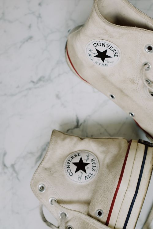 Free Detailed shot of vintage white high-top sneakers on marble surface. Stock Photo