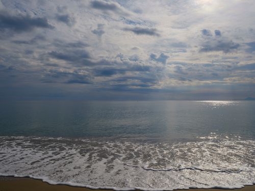 Free Peaceful ocean scenery with soft waves and cloudy sky, perfect for serene backgrounds. Stock Photo