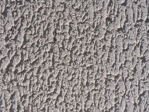 Free Close-up of a rough textured concrete wall, showcasing detailed patterns in natural light. Stock Photo