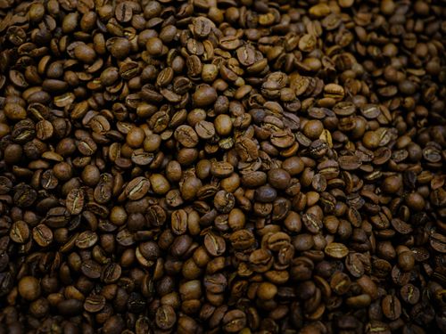 Free A close-up view of roasted coffee beans, highlighting their rich texture and aroma. Stock Photo