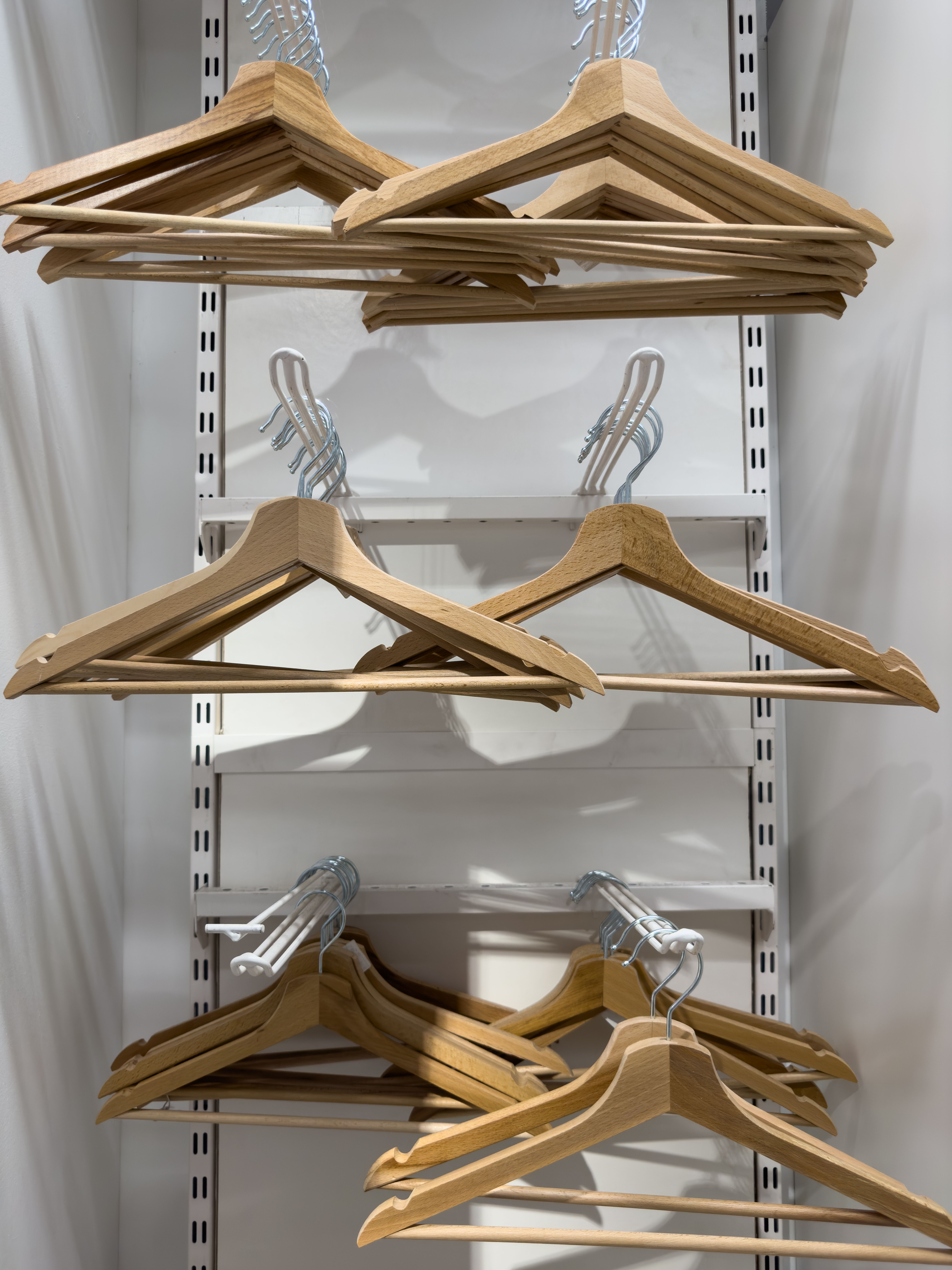 A minimalist closet with neatly arranged wooden hangers, perfect for organizing clothes.