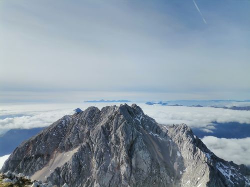 Free Stunning aerial view of a rugged mountain peak rising above cloud cover, captured in daylight. Stock Photo
