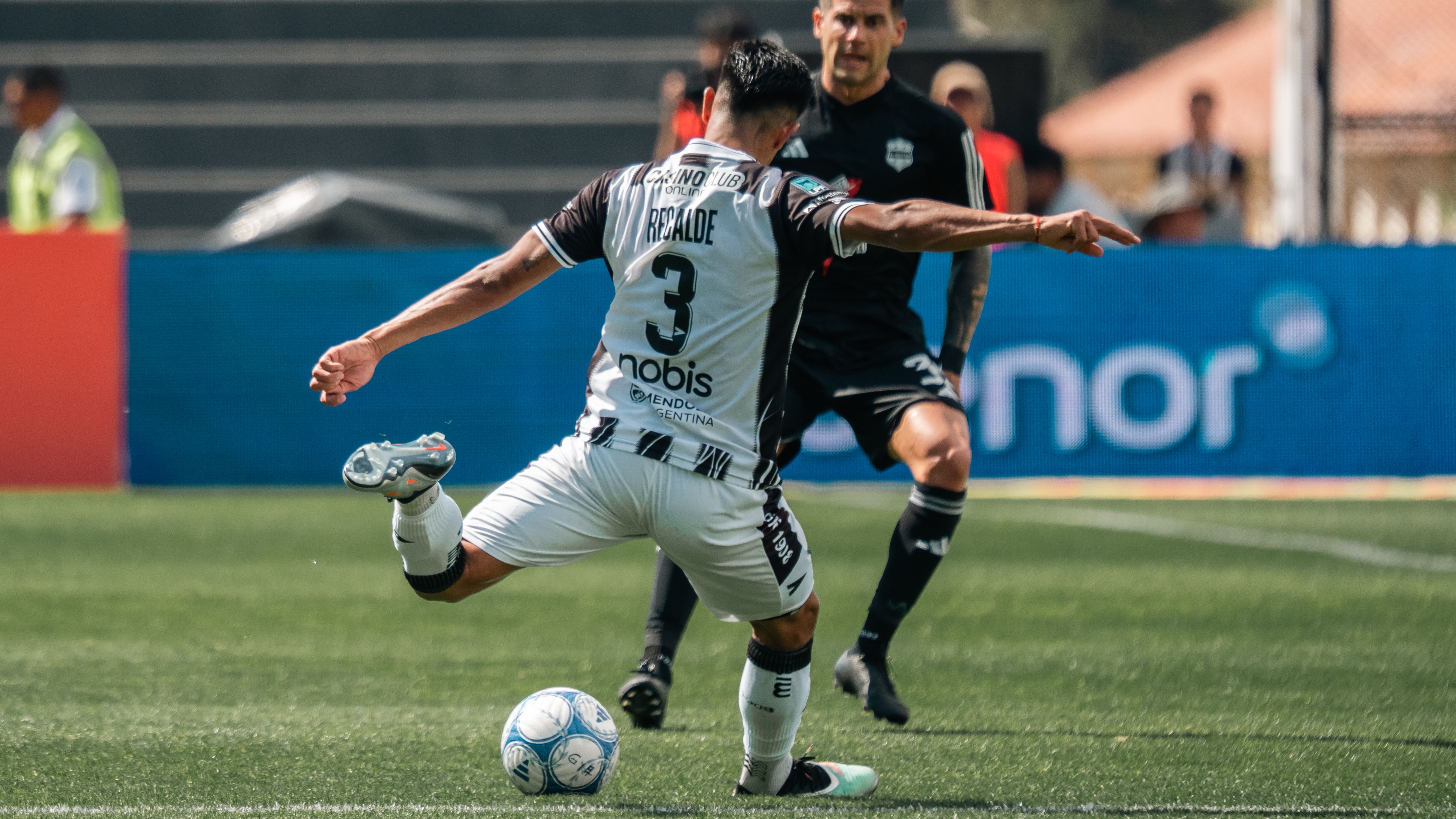 Fotomural Primer plano emocionante de un jugador de fútbol pateando el balón durante un partido.