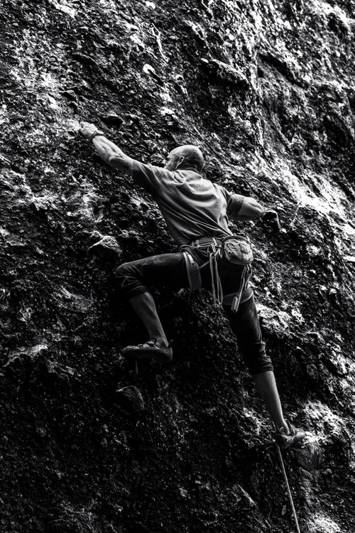 Free Dramatic monochrome image of a determined climber navigating a vertical rock face. Stock Photo
