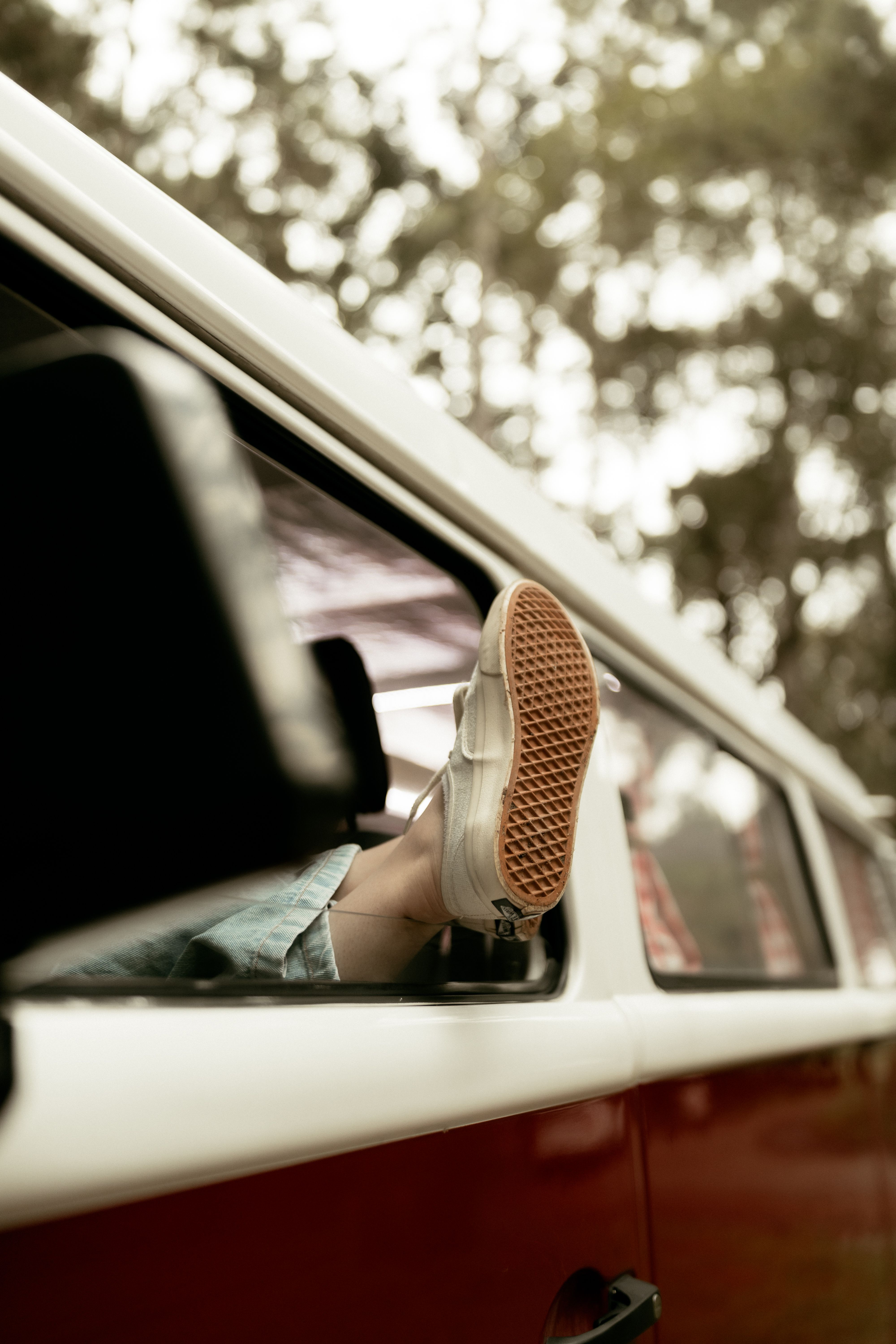 Foot sticking out of a vintage van window, capturing a sense of adventure and freedom.