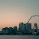 A smartphone displaying a single matching profile against a modern Singapore urban skyline background.