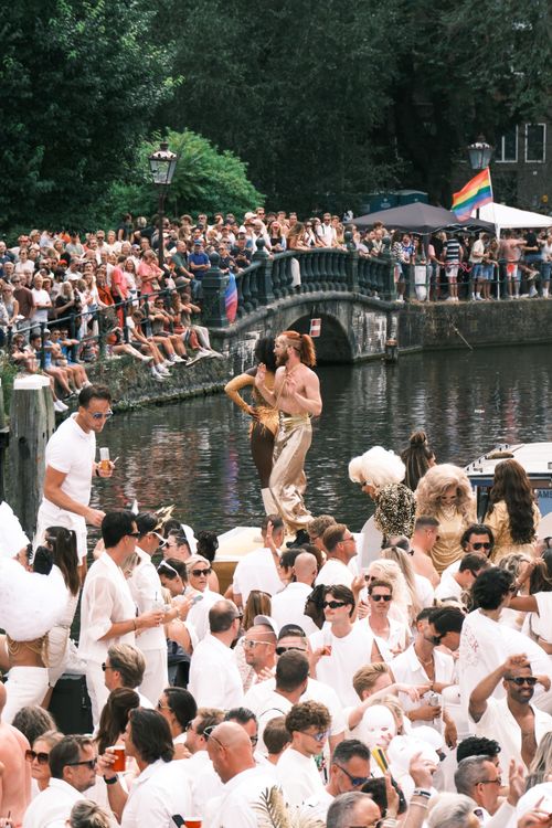Free Crowds enjoy a lively canal parade in Amsterdam with colorful costumes and festive atmosphere. Stock Photo